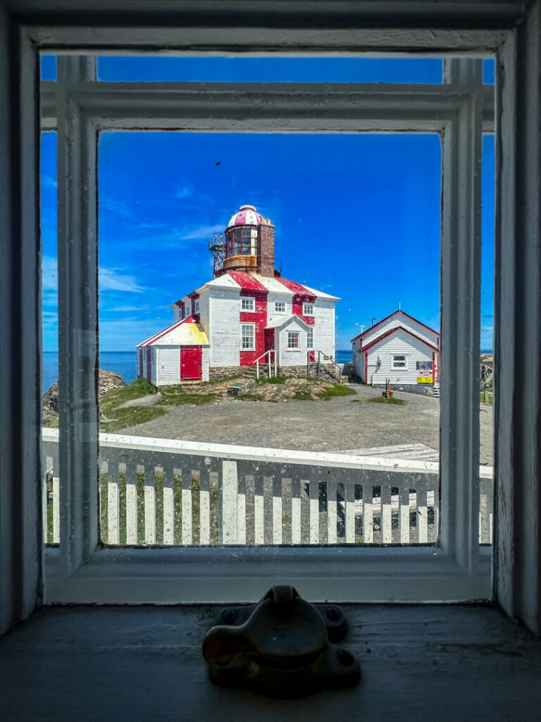 Cape Bonavista Lighthouse is framed in an old window in Newfoundland.