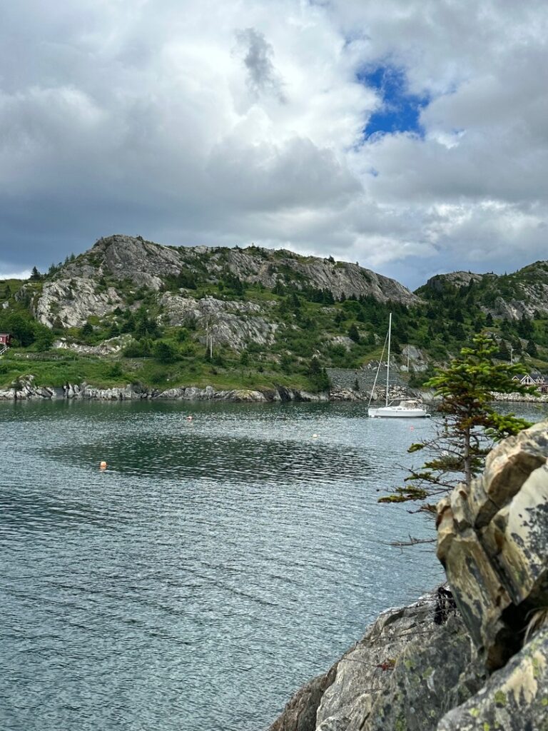 Waterfront view of Brigus Harbor with a sailboat, Brigus, Newfoundland.