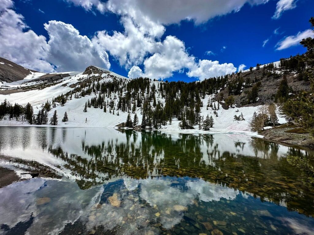 Amazing snow capped mountain reflections with blue sky shown on the alpine lakes loop trail.
