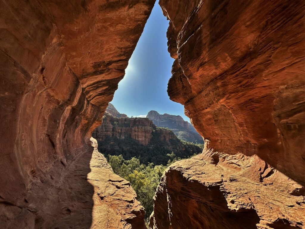 Morning light pours over the Subway Cave looking out into the Sedona desert during our hike to Subway Cave.