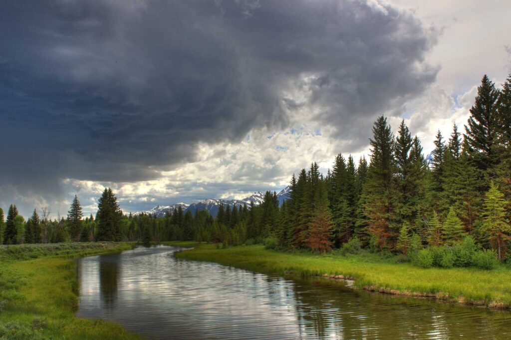 Dark clouds head toward hikers on the Schwabacher Landing Trail in Grand Teton National Park