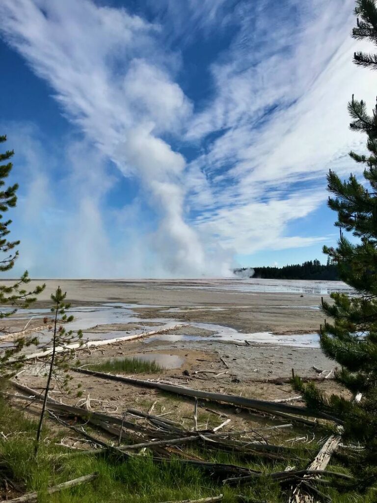 Steam rising from the Grand Prismatic Spring in the distance on the trail.