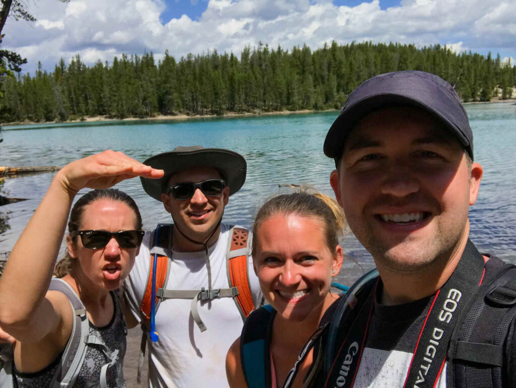 4 hikers pose for a selfie on the Clear Lake Trail, one of the easy hikes in Yellowstone we highly recommend.