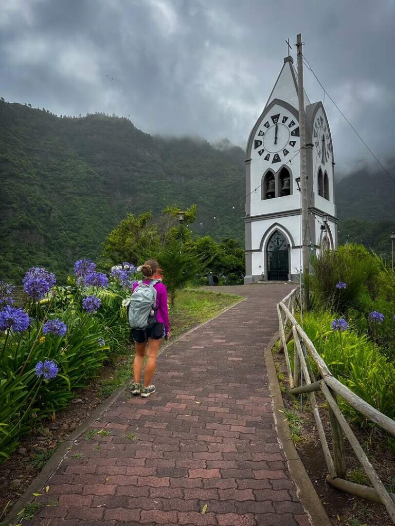A hiker stands in front of the unique Capelinha de Nossa Senhora de Fátima in Madeira.