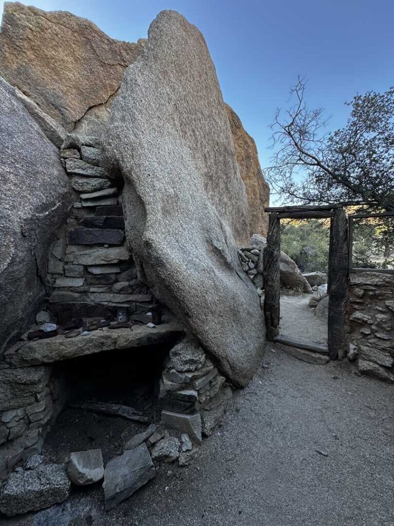 A makeshift fireplace and doorframe stand at the entrance to the Eagle Cliff Boulder House.