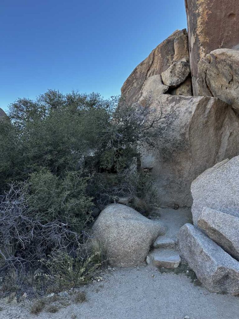 Two natural steps that lead to the entrance of a miner's boulder house.